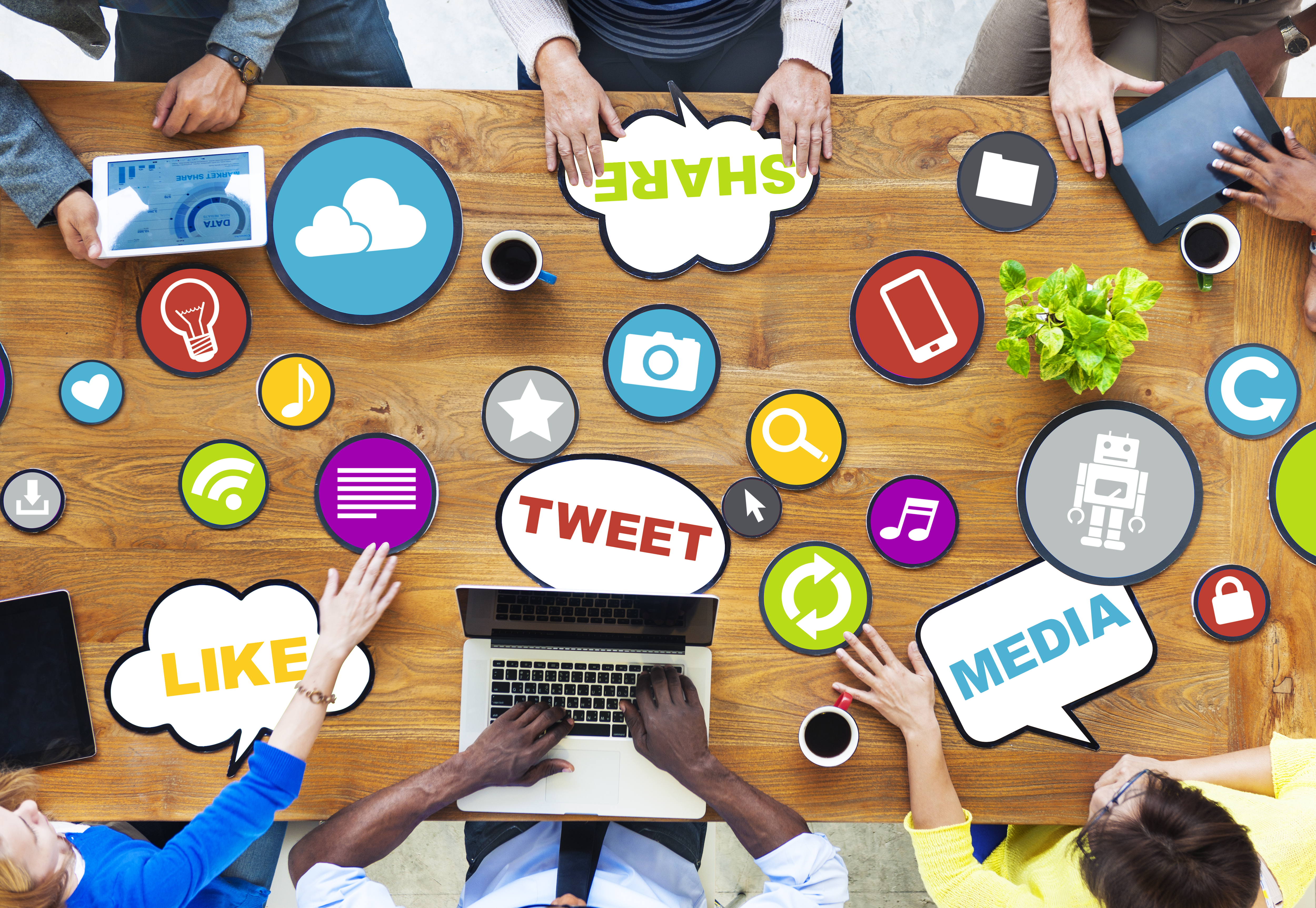 A group of people around a table using gadgets to Social Media Marketing - Influence